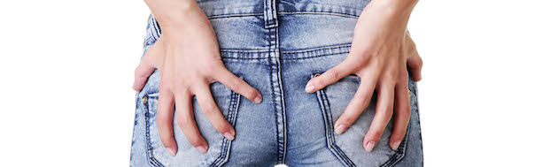 Girl in jeans holding bottom - possible hemorrhoids