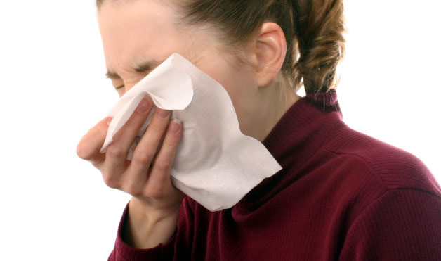 girl with asthmatic bronchitis coughing into a tissue