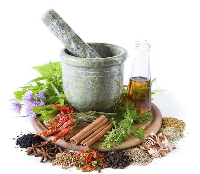 Herbs and spices with mortar and bottle with oil