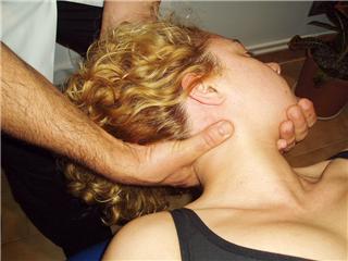 Osteopath manipulating head of patient
