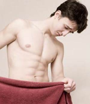 Man looking down behind towel at Genital Warts