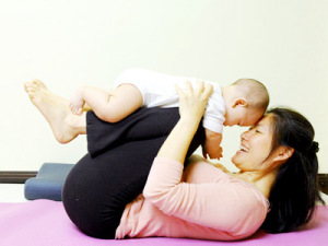 Babyyoga Woman doung yoga with baby